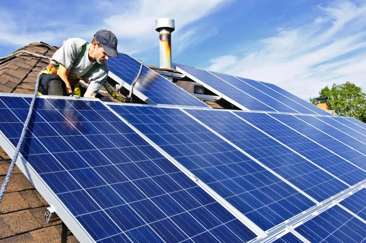 Installateur posant des panneaux photovoltaïques en toiture